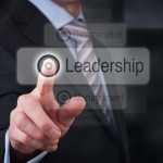 A businessman Pointing to a leadership button on a clear screen.